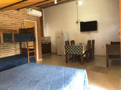 a room with a bed and a table and a tv at El Viejo Vagon in Mina Clavero