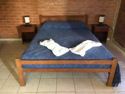 a bed with a blue comforter and two night stands at El Viejo Vagon in Mina Clavero