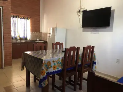 a kitchen with a table and chairs and a refrigerator at El Viejo Vagon in Mina Clavero