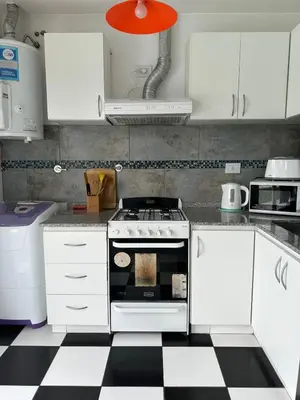 a kitchen with a stove and a checkered floor at La Francisca in Almafuerte