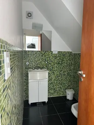 a green tiled bathroom with a sink and a toilet at La Francisca in Almafuerte