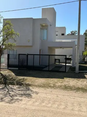 a white house with a fence in front of it at La Francisca in Almafuerte