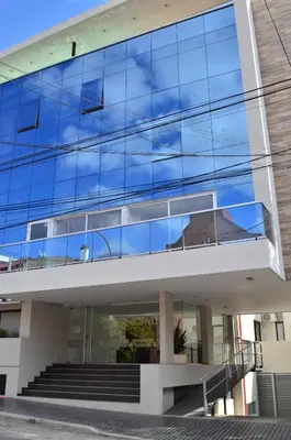 an office building with blue glass windows and stairs at Edificio PRISMA I in Villa Carlos Paz