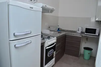 a kitchen with a white refrigerator and a stove at Edificio PRISMA I in Villa Carlos Paz