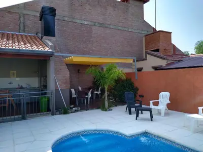 a patio with a pool and chairs and a building at Hostería Boutique El Puente Adults Only in Merlo
