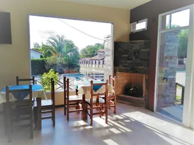 a dining room with a fireplace and a table and chairs at Hostería Boutique El Puente Adults Only in Merlo