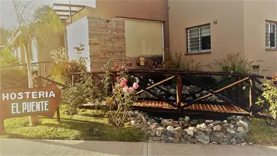a wooden bridge in front of a house at Hostería Boutique El Puente Adults Only in Merlo
