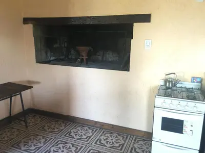 a kitchen with a stove and a fireplace at CABAÑA EN TANTI in Tanti