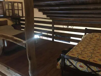 a room with a bed and a wooden floor at CABAÑA EN TANTI in Tanti
