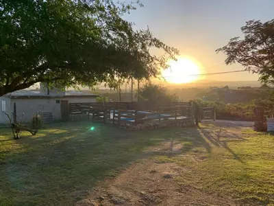 a barn with the sun setting in the background at CABAÑA EN TANTI in Tanti