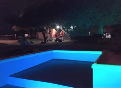 a swimming pool at night with blue lights at CABAÑA EN TANTI in Tanti