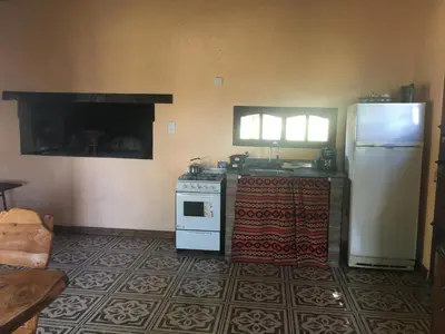 a kitchen with a refrigerator and a stove at CABAÑA EN TANTI in Tanti