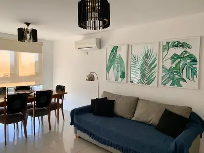 a living room with a blue couch and a table at ALOHA Güemes Premium, 2 dorm con Vista a las Sierras in Cordoba