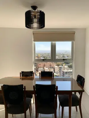 a dining room with a table and chairs and a window at ALOHA Güemes Premium, 2 dorm con Vista a las Sierras in Cordoba
