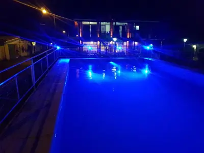 a swimming pool at night with blue lights at Aparts Piscu Yaco Almendros in Merlo