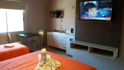a room with a bed and a tv on a wall at Aparts Piscu Yaco Almendros in Merlo