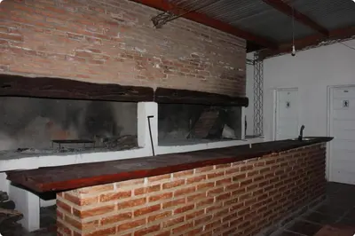 a brick fireplace in a room with a brick wall at Corral de Pirca in Los Reartes