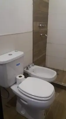 a bathroom with a white toilet and a sink at Corral de Pirca in Los Reartes