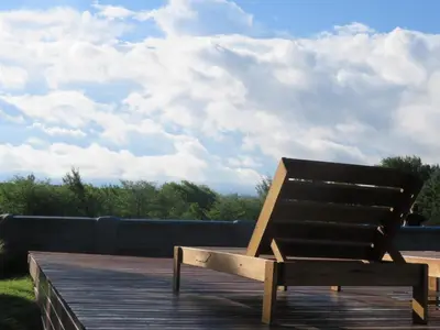 a wooden bench sitting on top of a wooden deck at Corral de Pirca in Los Reartes