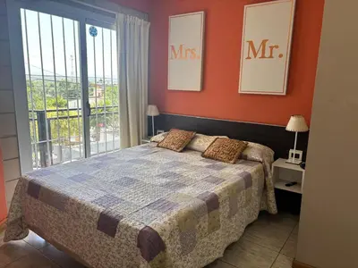a bedroom with a bed and a large window at Malaquias in Villa Carlos Paz