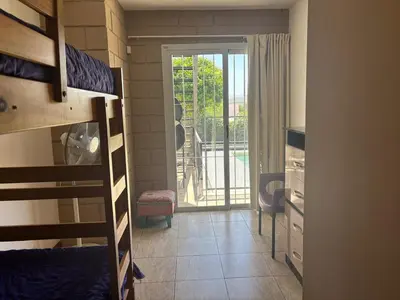 a room with bunk beds and a door to a balcony at Malaquias in Villa Carlos Paz