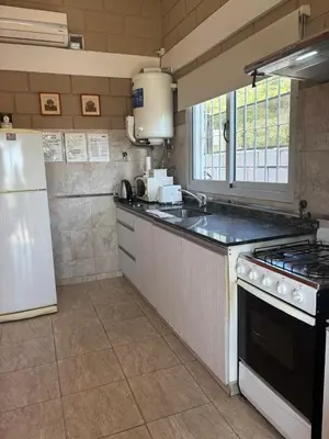 a kitchen with a stove and a white refrigerator at Malaquias in Villa Carlos Paz