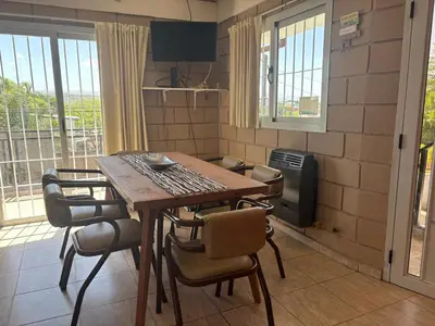 a kitchen with a wooden table and chairs in a room at Malaquias in Villa Carlos Paz