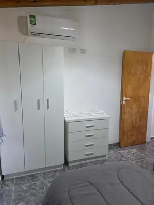 a bedroom with a bed and a dresser and a door at Complejo M&M in Bialet Massé