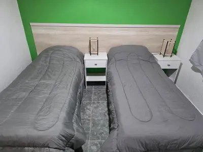 two beds in a room with green walls at Complejo M&M in Bialet Massé