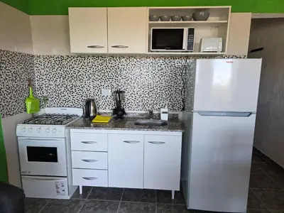 a white kitchen with a refrigerator and a microwave at Complejo M&M in Bialet Massé