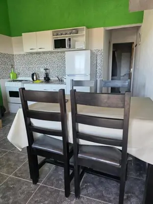 a kitchen with a table and two chairs in it at Complejo M&M in Bialet Massé