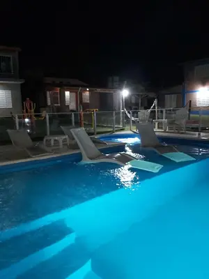 a swimming pool at night with chairs in it at Complejo M&M in Bialet Massé