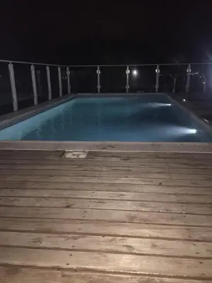 an empty swimming pool at night with a wooden deck at Complejo M&M in Bialet Massé