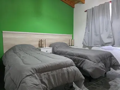 two beds in a room with a green wall at Complejo M&M in Bialet Massé