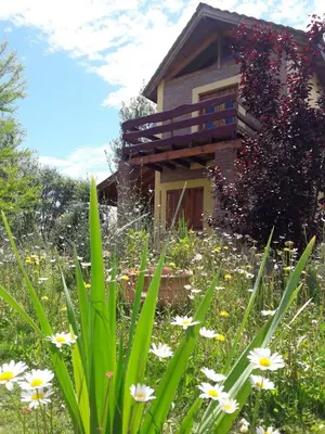 a garden in front of a house with flowers at Cabañas Vientos del Sur in Villa Yacanto