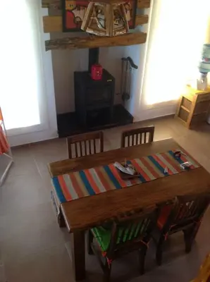 a wooden table and chairs in a living room at Cabañas Vientos del Sur in Villa Yacanto