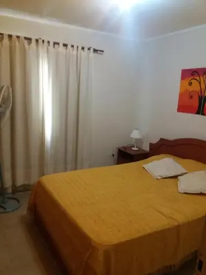 a bedroom with a bed with a yellow bedspread at Departamento Carlos Paz in Villa Carlos Paz