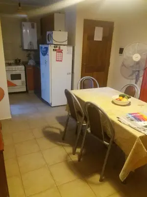 a kitchen with a table with chairs and a white refrigerator at Departamento Carlos Paz in Villa Carlos Paz