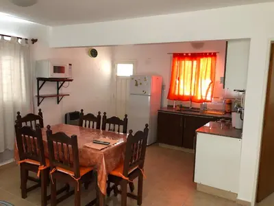 a kitchen with a table and chairs and a refrigerator at Dpto El Nilo Carlos Villa Paz in Villa Independencia