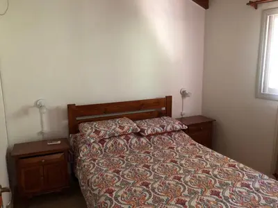 a bedroom with a bed and two night stands and a window at Dpto El Nilo Carlos Villa Paz in Villa Independencia