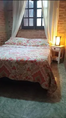 a bedroom with a bed and a table with a lamp at Abbá Departamentos in Mina Clavero