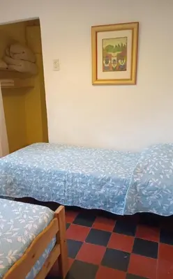 a bedroom with two beds and a picture on the wall at Abbá Departamentos in Mina Clavero