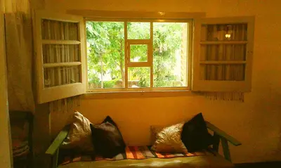 a couch sitting in a room with two windows at Abbá Departamentos in Mina Clavero