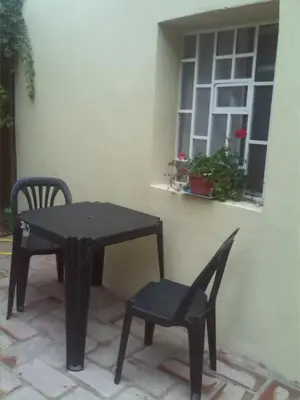 a black table and chair next to a window at Abbá Departamentos in Mina Clavero