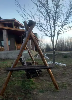 a set of wooden play equipment in front of a house at Libertad in Villa Yacanto
