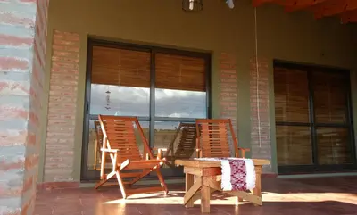 two rocking chairs and a table on a porch at Libertad in Villa Yacanto