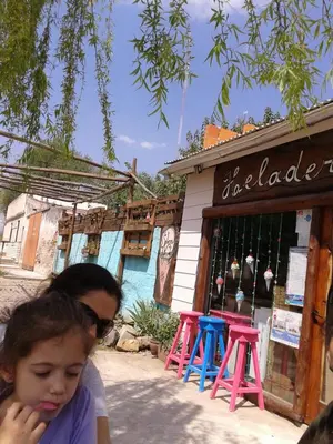a woman and a little girl standing in front of a store at Libertad in Villa Yacanto