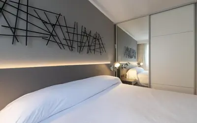a bedroom with a large white bed and a mirror at B131 - Argentina in Cordoba