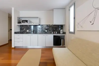 a kitchen with white cabinets and a couch in a room at B131 - Argentina in Cordoba