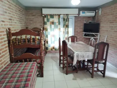 a dining room with a table and a bed at Los 5 de Brochero in Mina Clavero